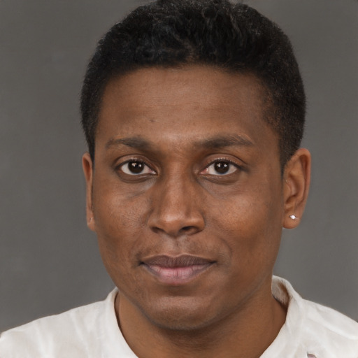 Joyful black young-adult male with short  brown hair and brown eyes