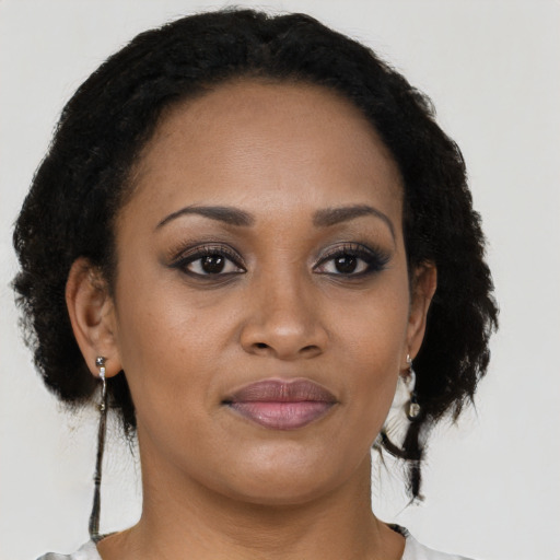 Joyful black young-adult female with short  brown hair and brown eyes