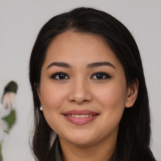 Joyful latino young-adult female with long  brown hair and brown eyes