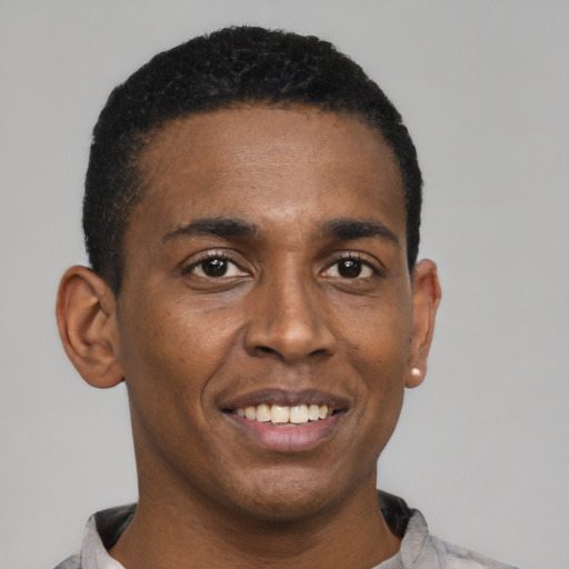 Joyful black young-adult male with short  black hair and brown eyes