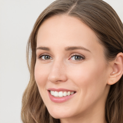 Joyful white young-adult female with long  brown hair and blue eyes