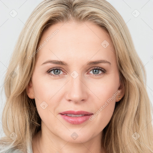 Joyful white young-adult female with long  brown hair and blue eyes