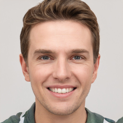 Joyful white young-adult male with short  brown hair and grey eyes