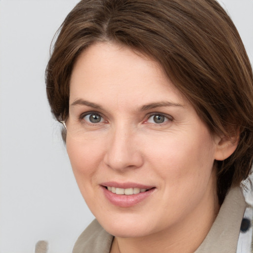 Joyful white adult female with medium  brown hair and brown eyes