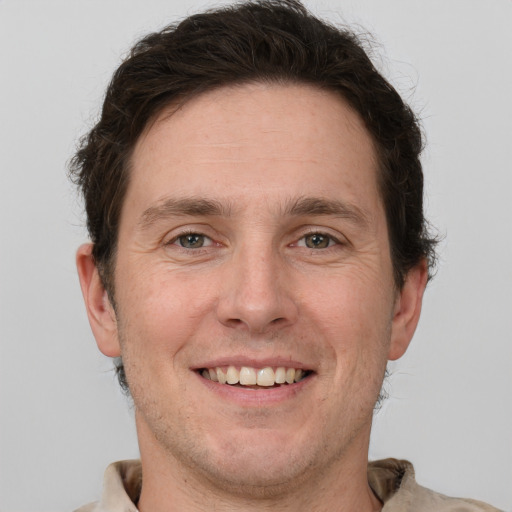 Joyful white adult male with short  brown hair and grey eyes