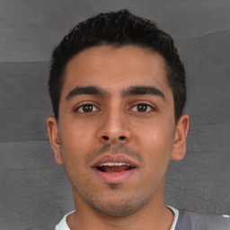 Joyful white young-adult male with short  black hair and brown eyes