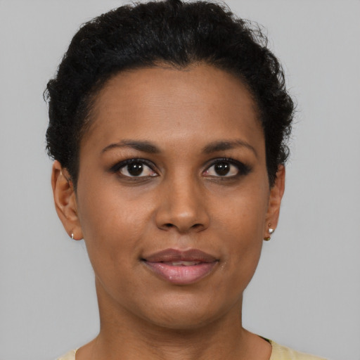 Joyful black young-adult female with short  brown hair and brown eyes