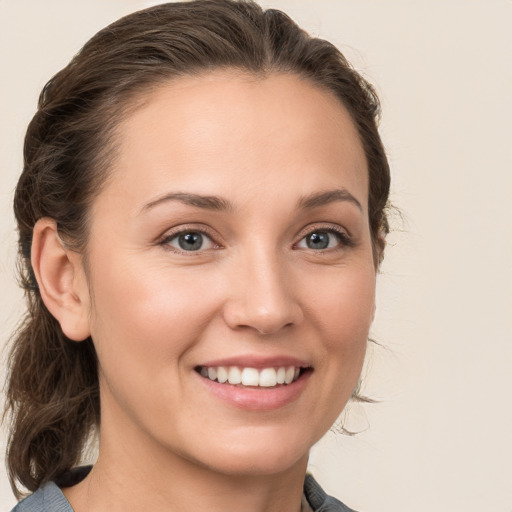 Joyful white young-adult female with medium  brown hair and grey eyes