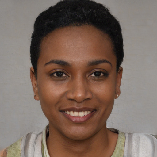 Joyful black young-adult female with short  black hair and brown eyes
