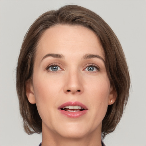 Joyful white young-adult female with medium  brown hair and green eyes