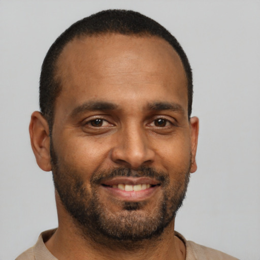 Joyful black young-adult male with short  black hair and brown eyes