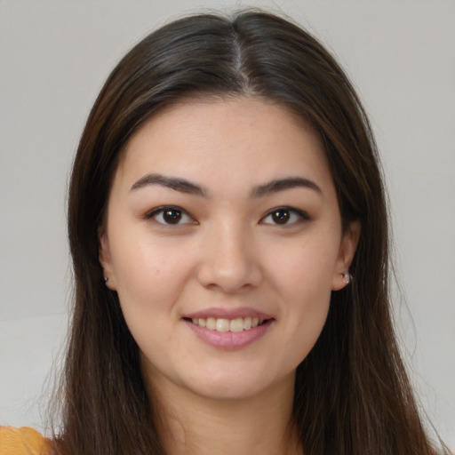 Joyful asian young-adult female with long  brown hair and brown eyes