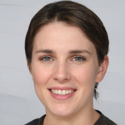 Joyful white young-adult female with medium  brown hair and grey eyes