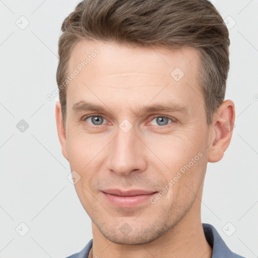 Joyful white young-adult male with short  brown hair and grey eyes