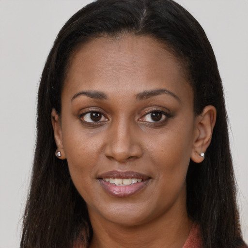 Joyful black young-adult female with long  brown hair and brown eyes