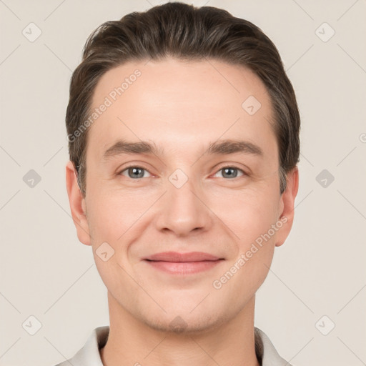 Joyful white young-adult male with short  brown hair and grey eyes