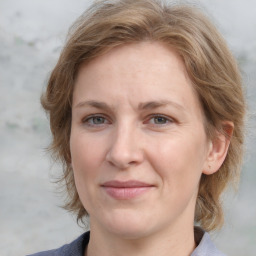 Joyful white adult female with medium  brown hair and blue eyes