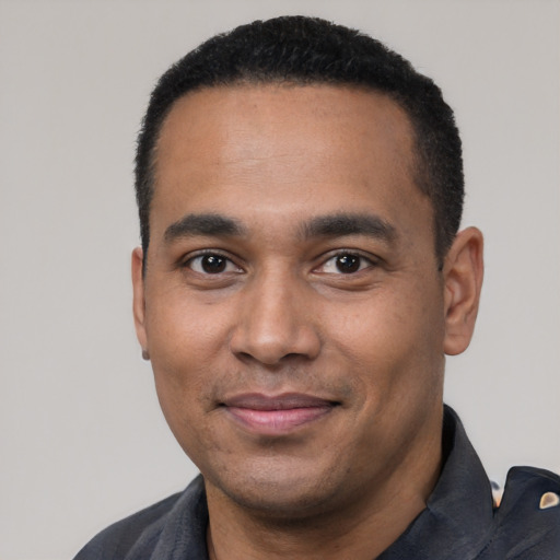 Joyful black young-adult male with short  black hair and brown eyes