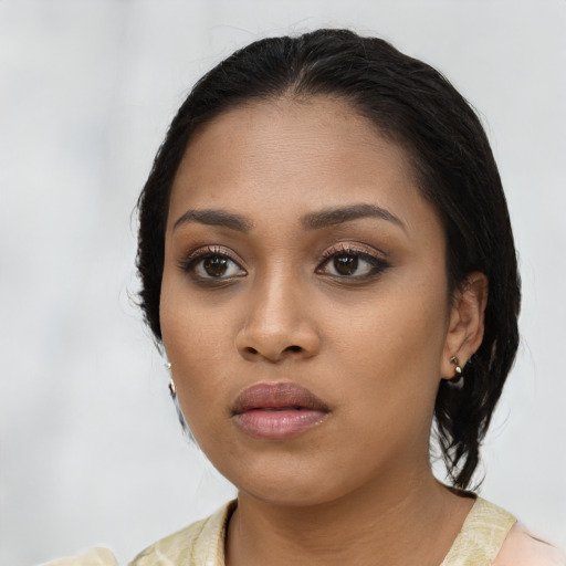Joyful black young-adult female with long  black hair and brown eyes