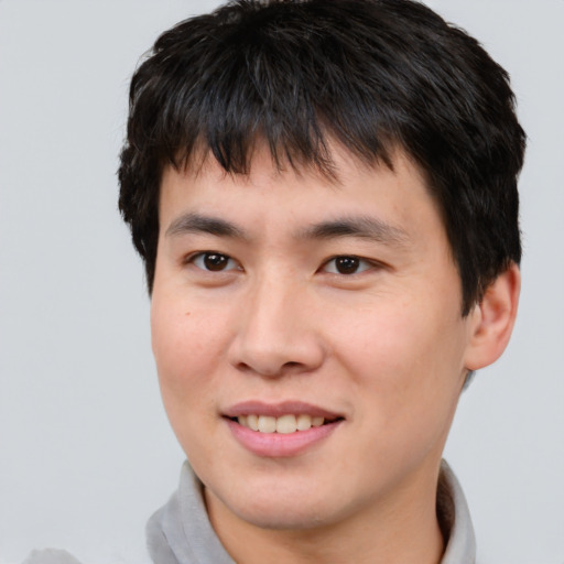 Joyful asian young-adult male with short  brown hair and brown eyes
