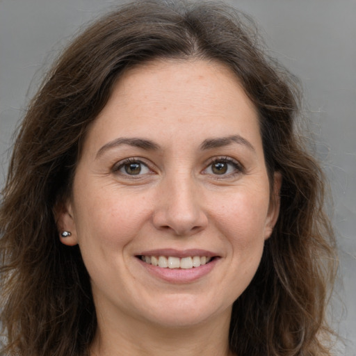 Joyful white adult female with long  brown hair and brown eyes