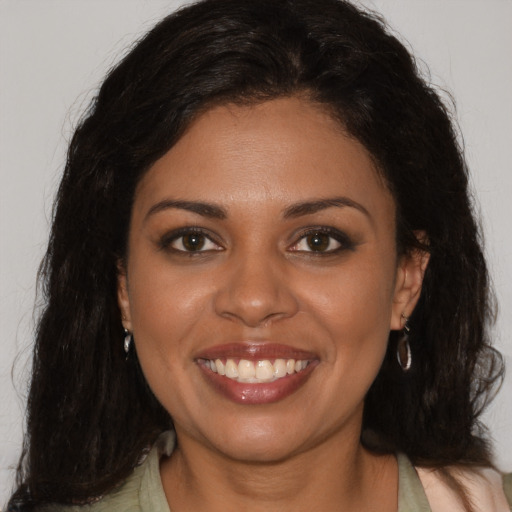 Joyful black young-adult female with long  brown hair and brown eyes