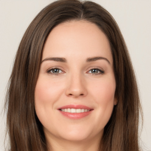 Joyful white young-adult female with long  brown hair and brown eyes