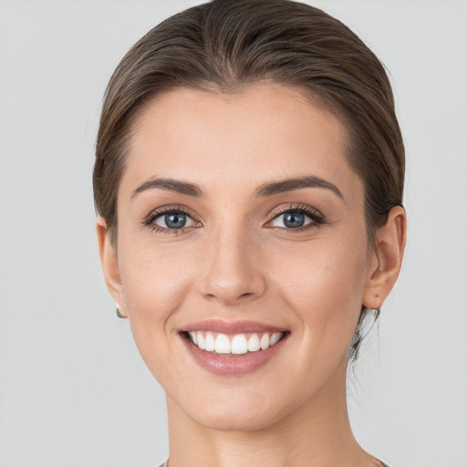 Joyful white young-adult female with short  brown hair and grey eyes