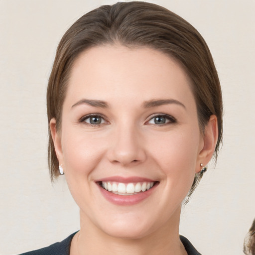 Joyful white young-adult female with medium  brown hair and grey eyes