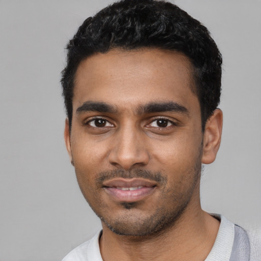 Joyful black young-adult male with short  black hair and brown eyes