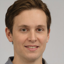 Joyful white adult male with short  brown hair and grey eyes