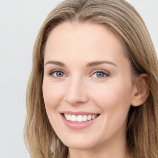 Joyful white young-adult female with long  brown hair and grey eyes