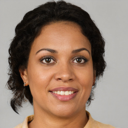 Joyful latino adult female with medium  brown hair and brown eyes
