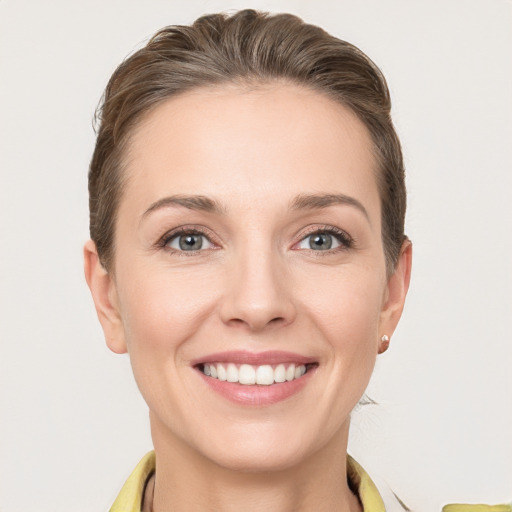 Joyful white young-adult female with short  brown hair and grey eyes