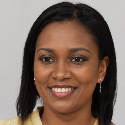 Joyful black young-adult female with long  brown hair and brown eyes