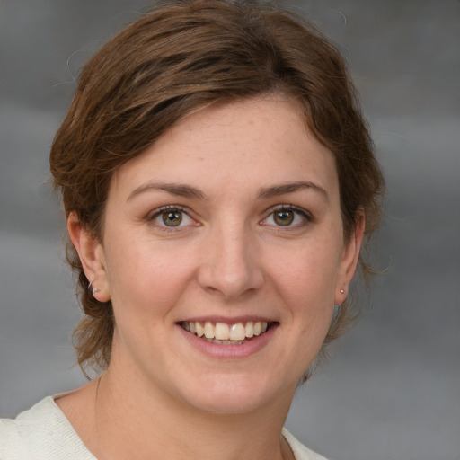 Joyful white young-adult female with medium  brown hair and grey eyes