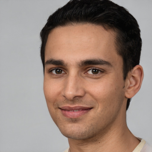 Joyful white young-adult male with short  black hair and brown eyes