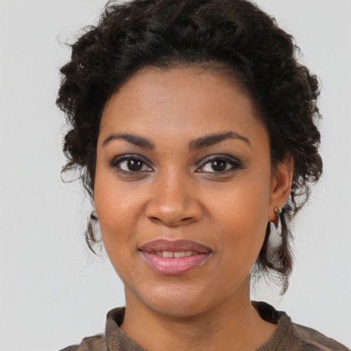 Joyful black young-adult female with medium  brown hair and brown eyes