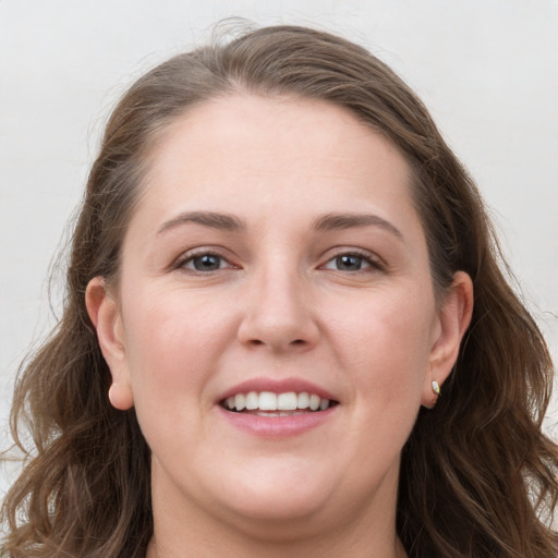 Joyful white young-adult female with long  brown hair and grey eyes