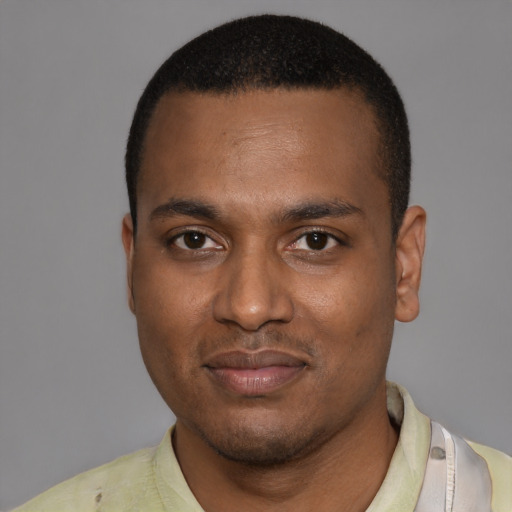 Joyful black young-adult male with short  black hair and brown eyes