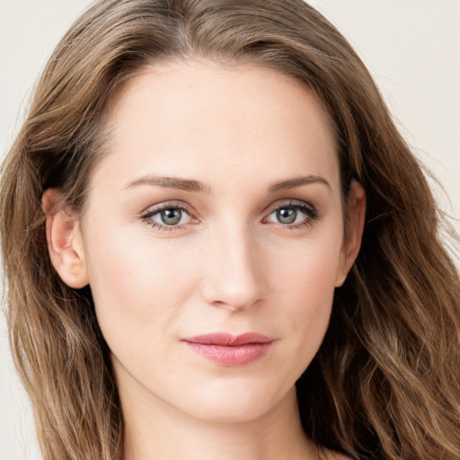 Joyful white young-adult female with long  brown hair and blue eyes