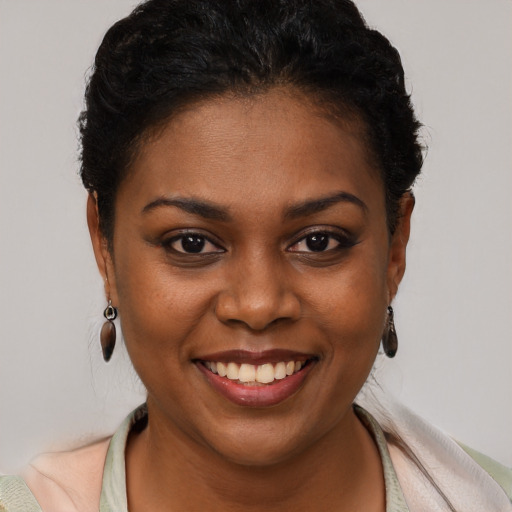 Joyful black young-adult female with short  brown hair and brown eyes