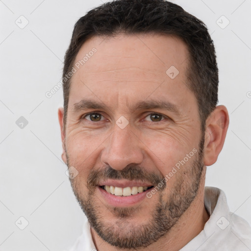 Joyful white adult male with short  brown hair and brown eyes