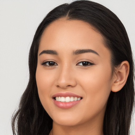 Joyful latino young-adult female with long  brown hair and brown eyes