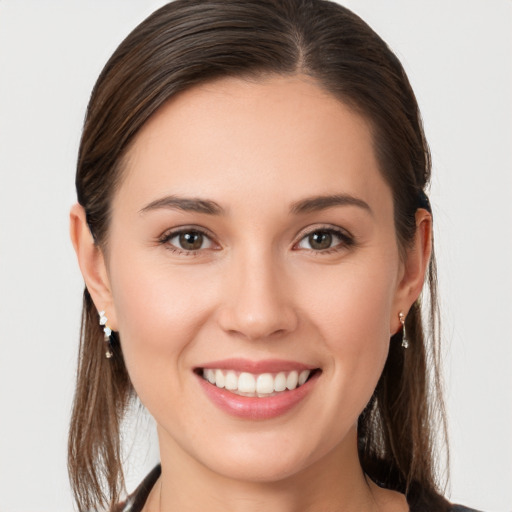 Joyful white young-adult female with long  brown hair and brown eyes