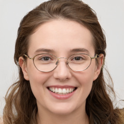 Joyful white young-adult female with long  brown hair and blue eyes