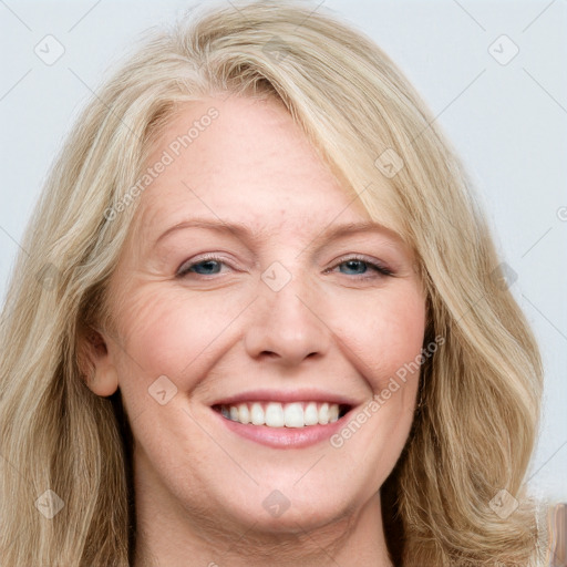 Joyful white adult female with long  brown hair and blue eyes