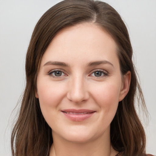 Joyful white young-adult female with long  brown hair and grey eyes