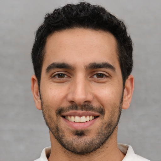 Joyful white young-adult male with short  black hair and brown eyes
