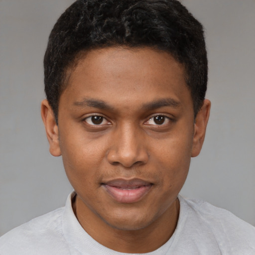 Joyful black young-adult male with short  brown hair and brown eyes